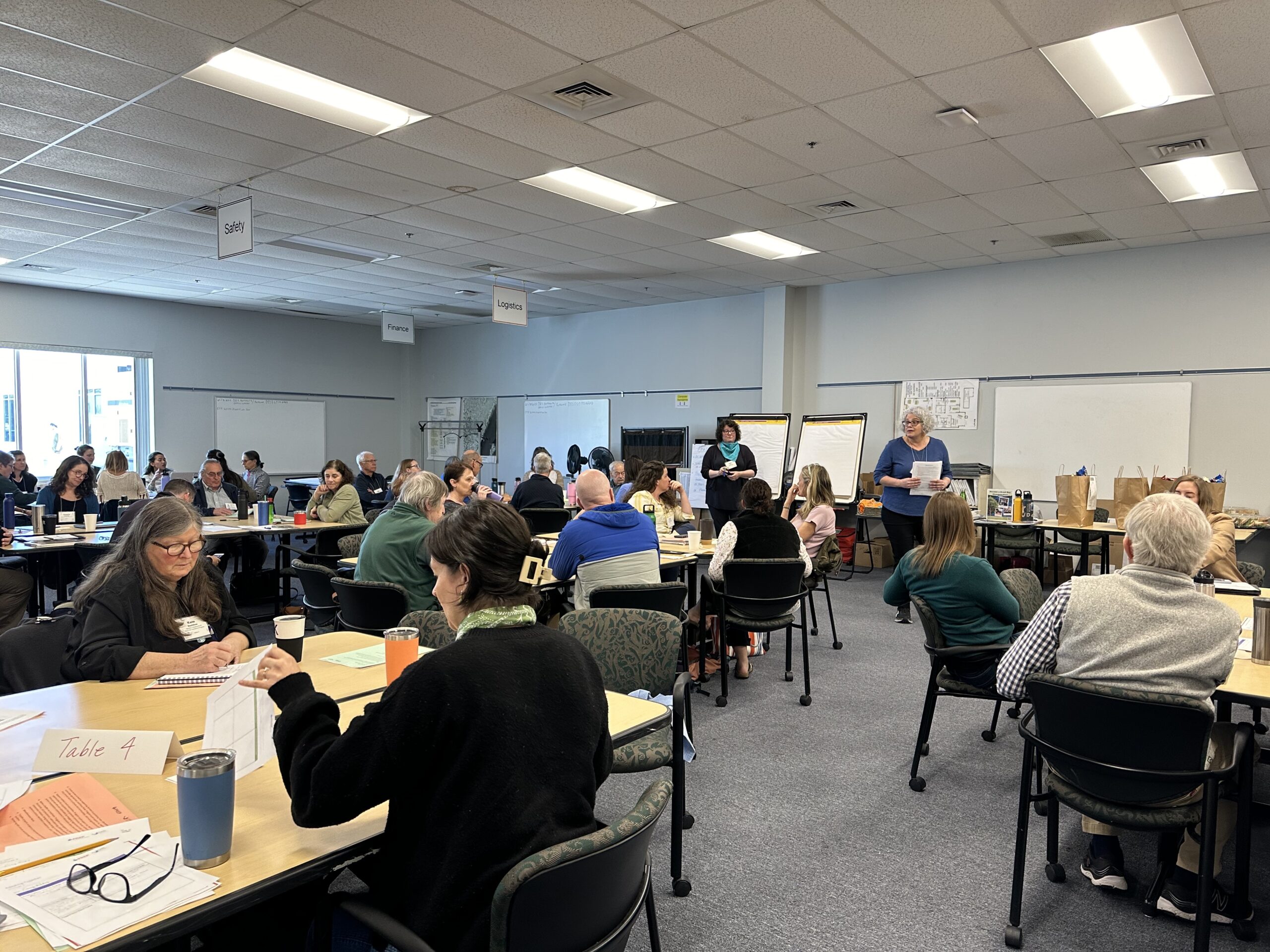 A large room full of attendees sitting in chairs at the Adapting Together Workshop in Portsmouth, NH.